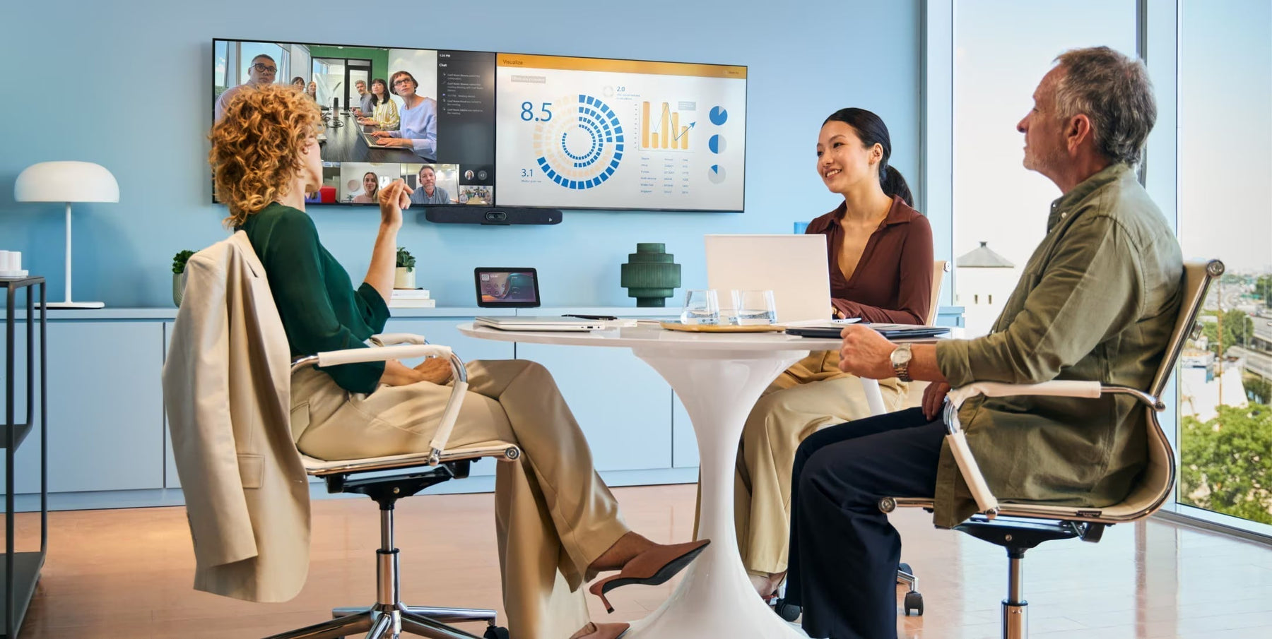 Small meeting room with three professionals using a Poly Studio USB video bar for a hybrid BYOD video conference on a large display